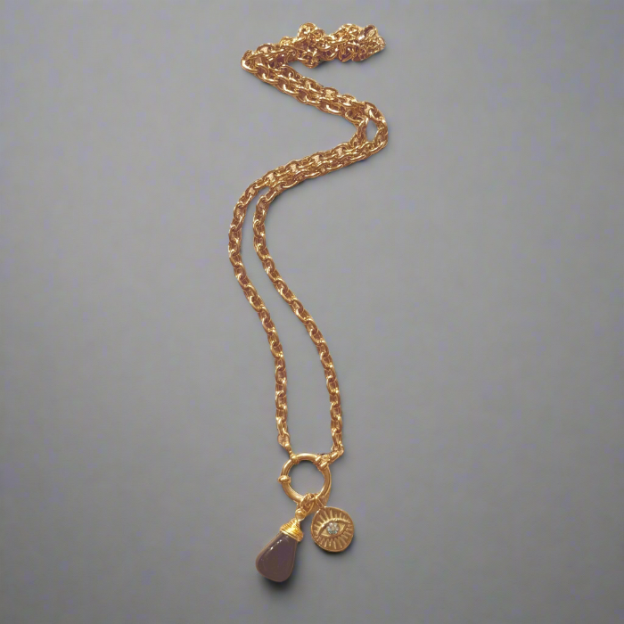 Gold necklace with a pendant on a gray background